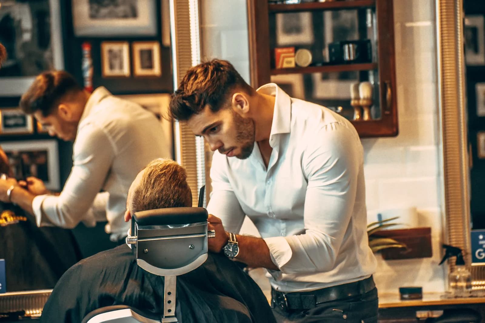 Gergő Koródy in a white shirt cutting a client's hair in the salon