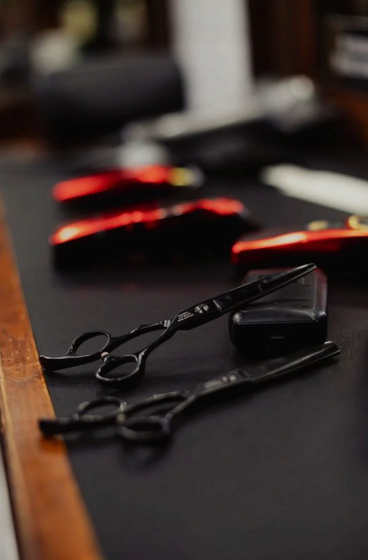 Scissors and a razor on the black counter