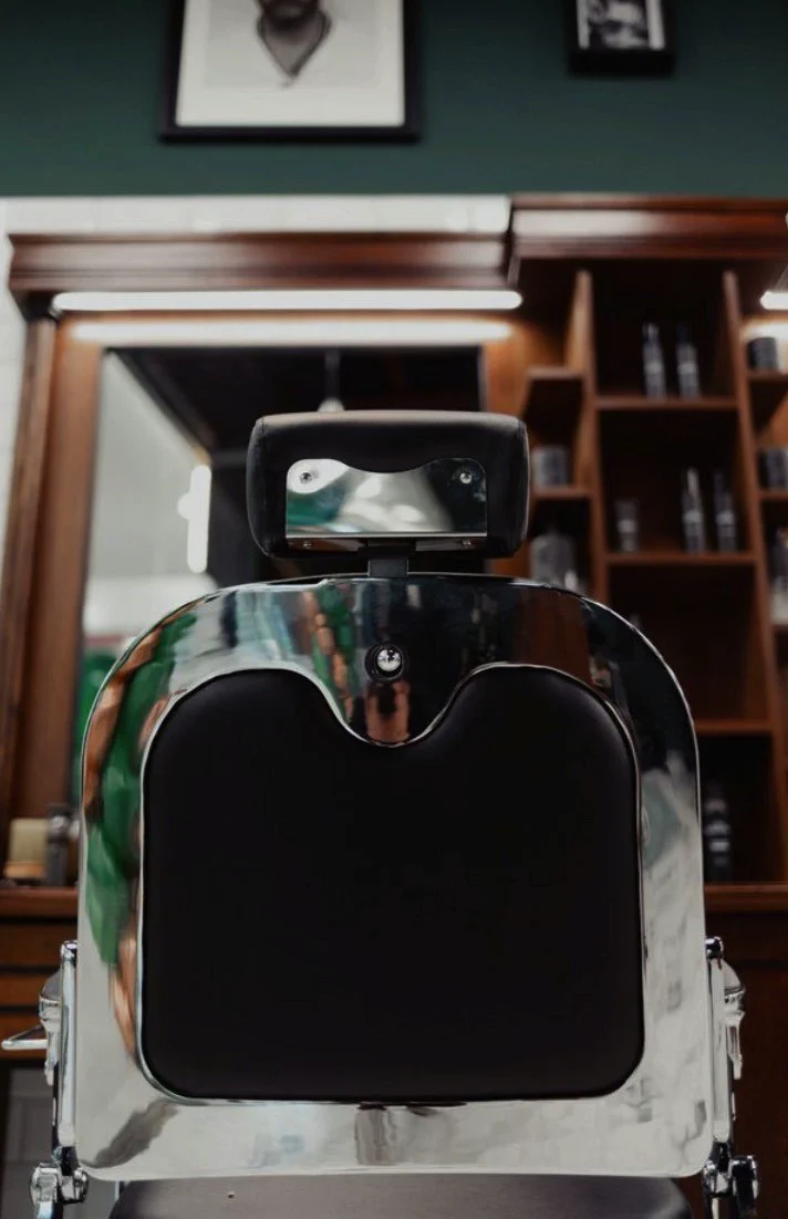Chrome barber chair in front of the mirror